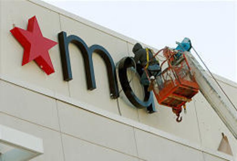 Eddie Manesh places a Macy's logo on a former Rich's department store in Atlanta this week. Rich's has been a popular local brand name.