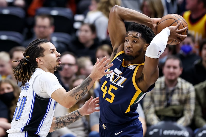 Utah Jazz guard Donovan Mitchell (45) looks to pass around Orlando Magic guard Cole Anthony (50) during the game at Vivint Arena in Salt Lake City on Friday, Feb. 11, 2022.