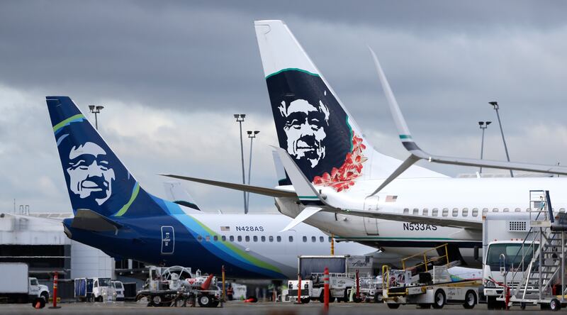FILE - In this Monday, April 4, 2016, file photo, Alaska Airlines planes with the company's new livery and tail logo, left, and the old livery used to promote service to Hawaii, right, are shown parked at Seattle-Tacoma International Airport in Seattle. A