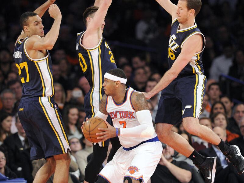 New York Knicks' Carmelo Anthony looks to shoot as he is guarded by Utah Jazz center Rudy Gobert (27), Gordon Hayward (20) and Steve Novak, right, during the third quarter of an NBA basketball game Friday, Nov. 14, 2014, at Madison Square Garden in New Yo