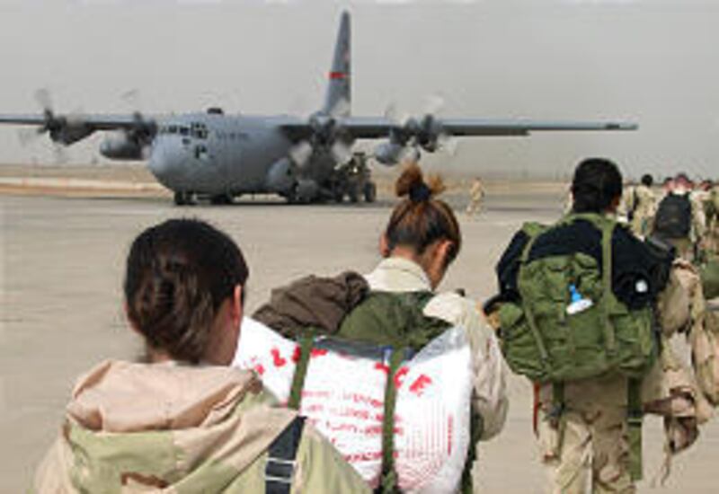 Members of the Army's 32nd Signal Battalion board an Air Force C-130 transport plane as they prepare to leave Iraq from an airstrip in Balad. More than 100,000 Americans are being replaced by fresh forces.