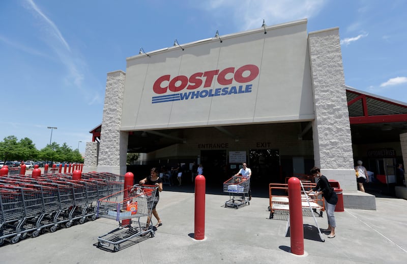 In this June 4, 2014, photo, shoppers push carts out of a Costco in Plano, Texas.