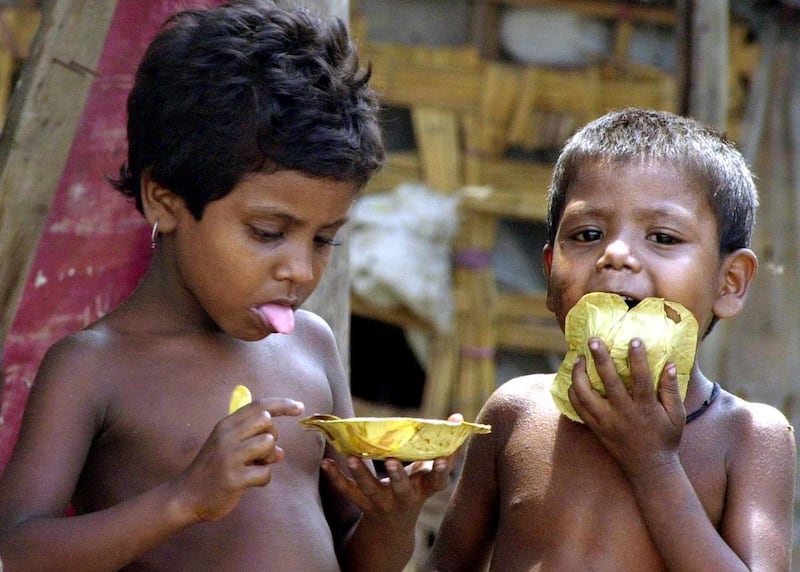 Indian children from a slum eat on the banks of the polluted river Yamuna in New Delhi, India Saturday, Aug. 31, 2002. The 10-day World Summit has been focusing on ways to get water, electricity, education and health care to the world's poorest while prot