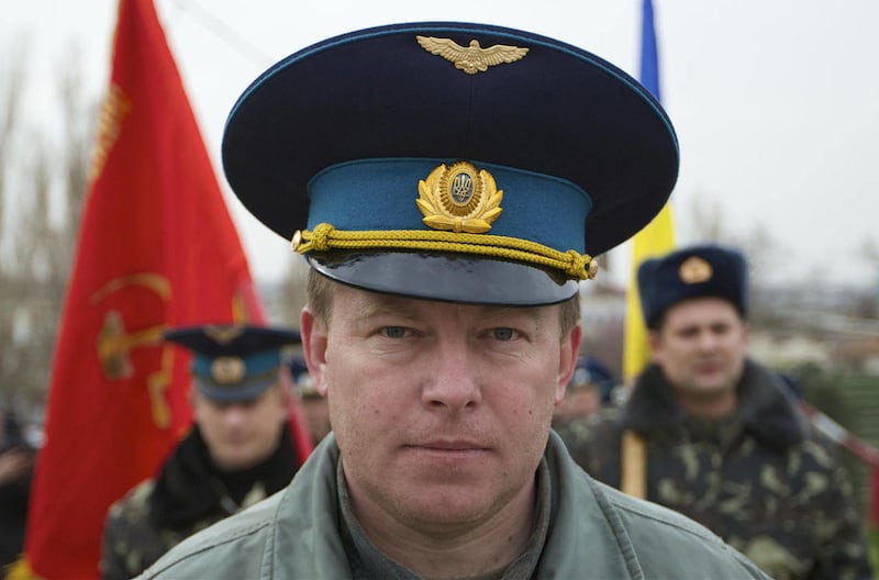 In this Tuesday, March 4, 2014 file photo, Air Force Col. Yuliy Mamchur, commander of the Ukrainian Belbek Air Base, leads his men to the base outside Sevastopol, Ukraine.