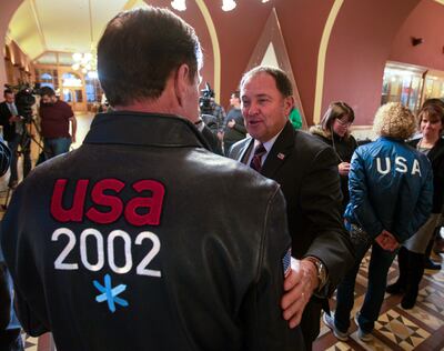 FILE - Gov. Gary Herbert, center, talks with Fraser Bullock, chief operating officer of the 2002 Winter Games, after the USOC choose Salt Lake over Denver to bid on behalf of the US for future Winter Games. Salt Lake City Mayor Jackie Biskupski held a pre