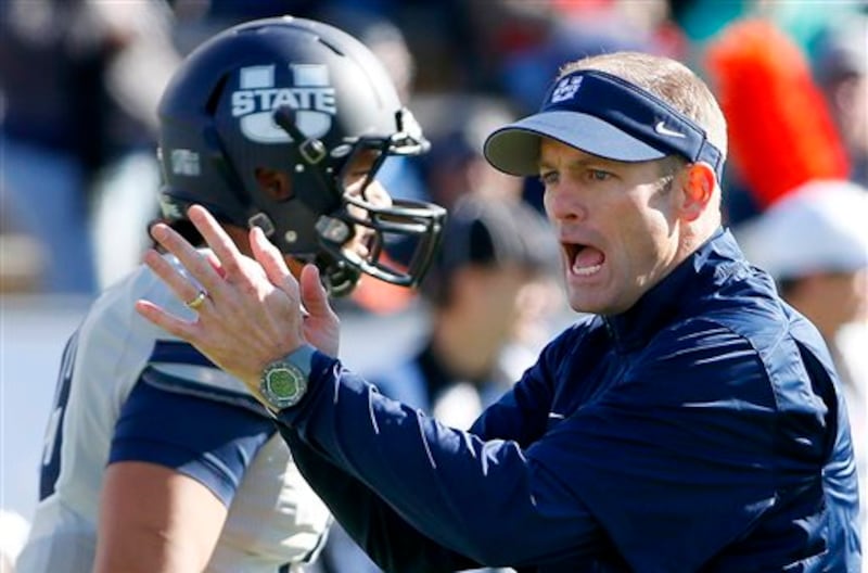 Utah State head coach Matt Wells cheers along with players prior to a New Mexico Bowl game against UTEP on Dec. 20, 2014.
