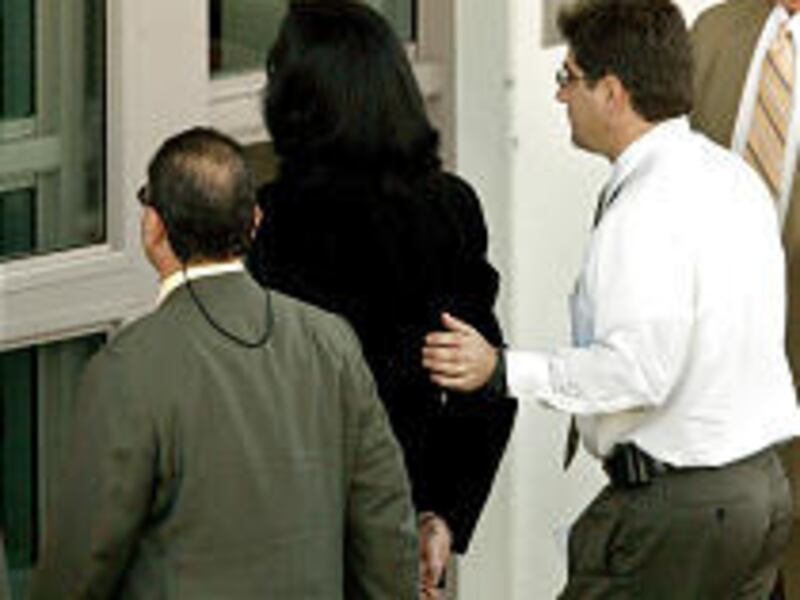 A handcuffed Michael Jackson is escorted into Santa Barbara County Jail to be arraigned on child molestation charges in Santa Barbara, Calif., Thursday.