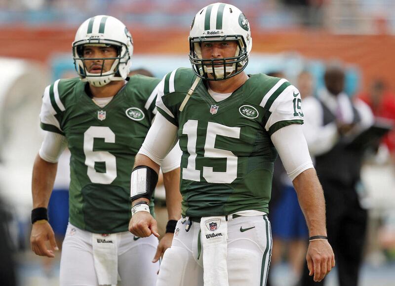 FILE - In this Sept. 23, 2012, file photo, New York Jets quarterbacks Tim Tebow (15) and Mark Sanchez (6) warm up before an NFL football game against the Miami Dolphins in Miami .