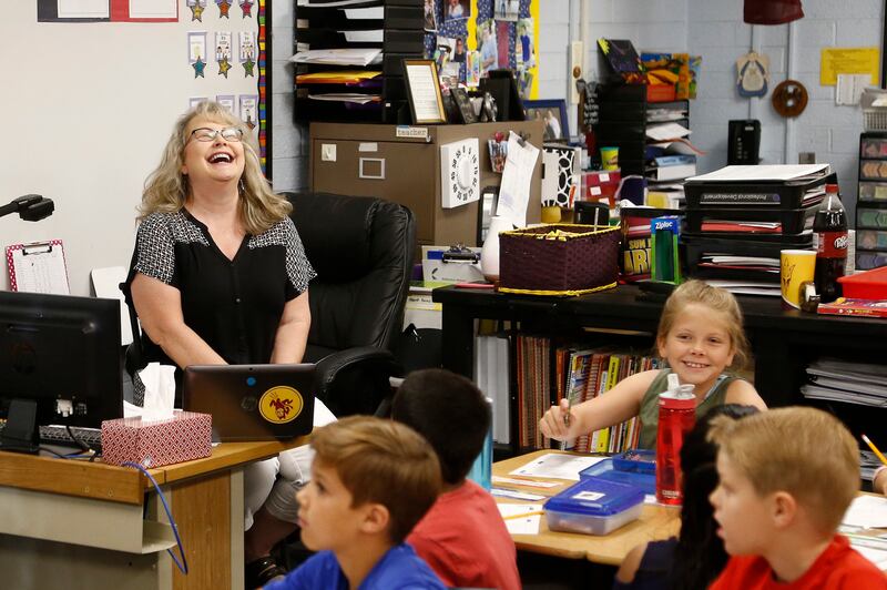Cindy Cordts, a third grade teacher at Oakwood Elementary School, laughs along with some of her students.