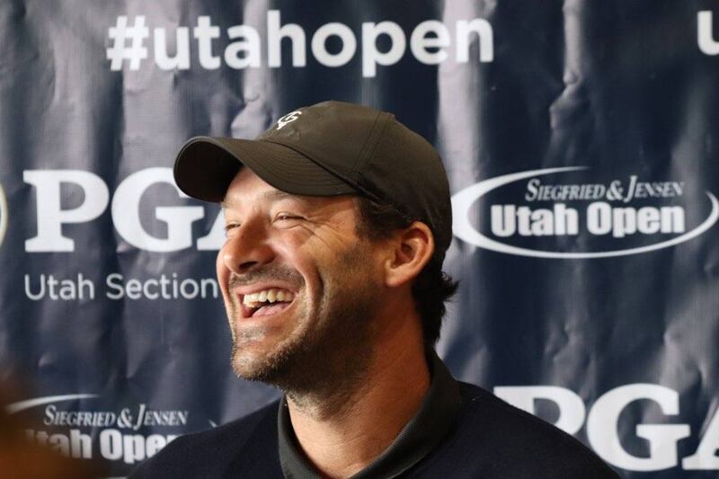 Former NFL quarterback and current CBS football broadcaster Tony Romo enjoys a laugh during Utah Open press conference.