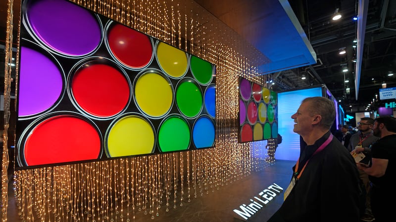 A CES attendee looks at the TCL high-end Mini LED Ultra Q TV at TCL booth in the CES tech show in Las Vegas.