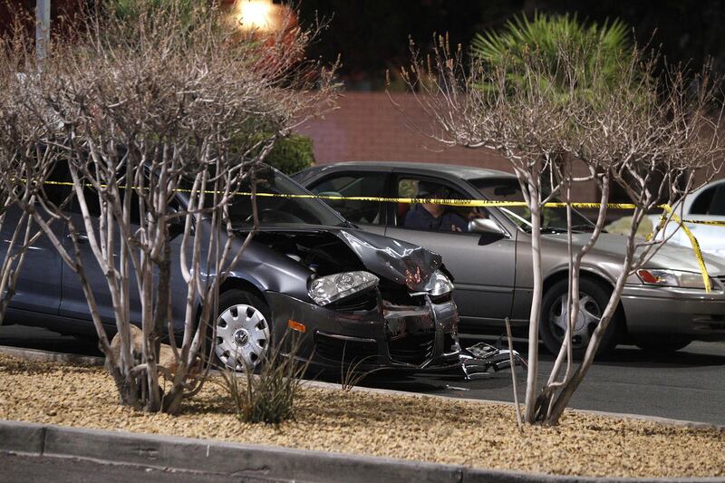 FILE - In this Jan. 21, 2014 file photo, a damaged car is seen at the scene of a fatal road rage incident near the corner of Tropicana Avenue and Rainbow Boulevard in Las Vegas. Authorities say a man shot a motorist to death in a vehicle with two children