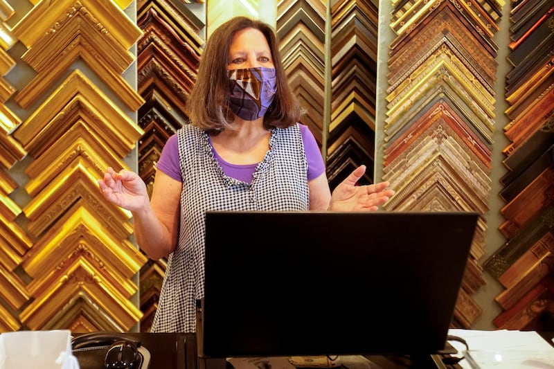 Karen Raab talks with a customer at Chemers Gallery Thursday, May 7, 2020, in Tustin, Calif. Business owners across California anxiously awaited new guidelines Thursday from California Gov. Gavin Newsom that will outline the first widespread changes to a statewide stay-at-home order that shut most retail shops to slow the spread of the coronavirus.