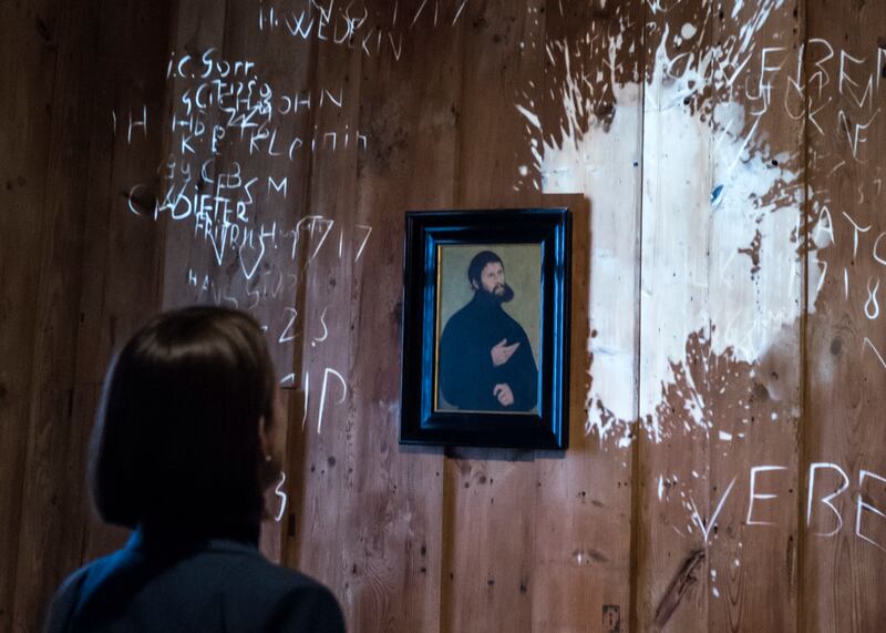 A woman stands in front of a video installation in the historical Luther room, where Martin Luther translated the Bible, during a press preview of the exhibition 'Luther and the Germans' at the Wartburg Castle, where Martin Luther translated the New Testa