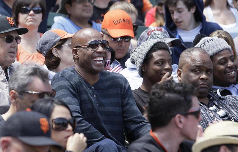 Former baseball player Barry Bonds laughs as he watches a baseball game between the San Francisco Giants and the Arizona Diamondbacks in San Francisco, Monday, May 28, 2012.