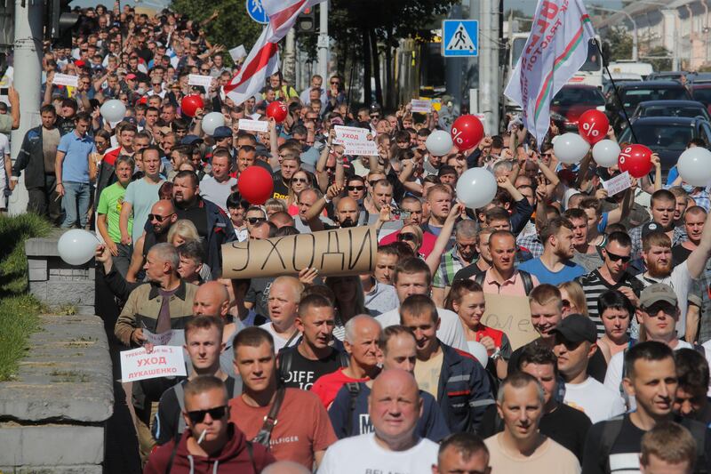 Workers with handmade posters reading “Go away!” march toward the Minsk Wheel Tractor Plant where Belarusian President Alexander Lukashenko addresses employees in Minsk, Belarus, Monday, Aug. 17, 2020.