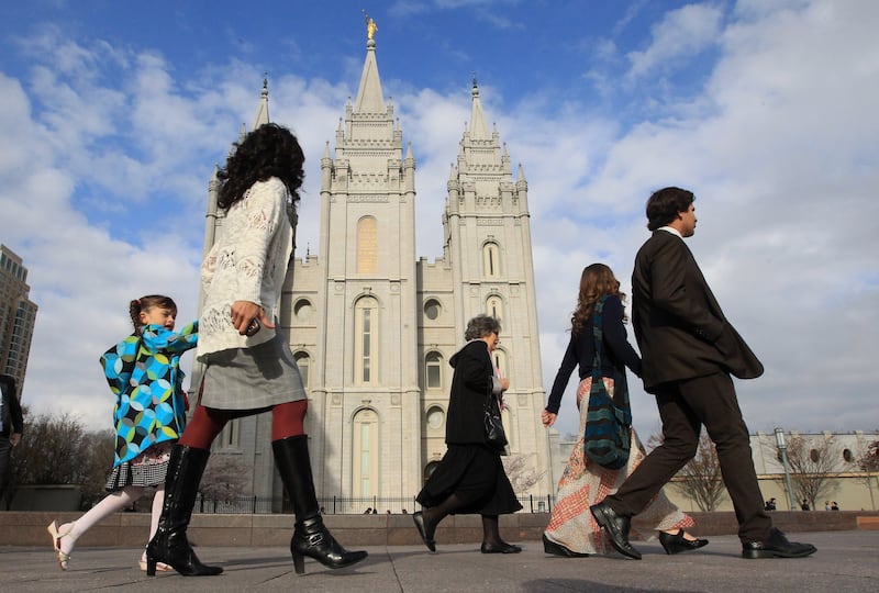 People walk pass the Salt Lake Temple on the way to the Conference Center during the opening session of the two-day general conference of The Church of Jesus Christ of Latter-day Saints on Saturday, April 5, 2014, in Salt Lake City.