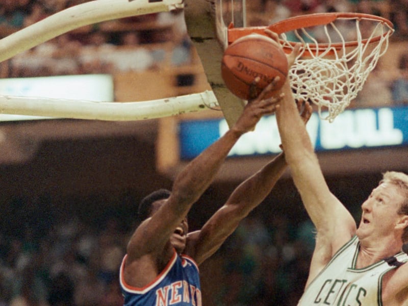Boston Celtics star Larry Bird right slaps away a drive to the basket by the New York Knicks Gerald Wilkins