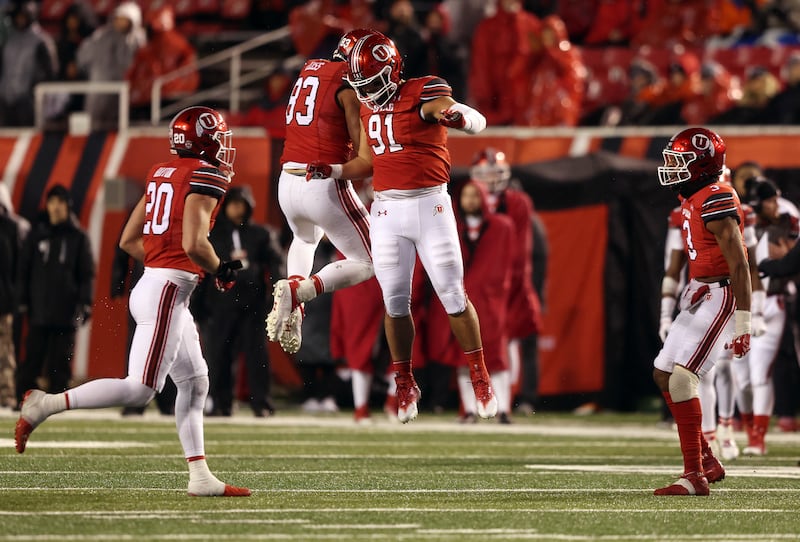 Utah Utes defensive ends Jonah Elliss (83) and Gabe Reid (91) celebrate a play.
