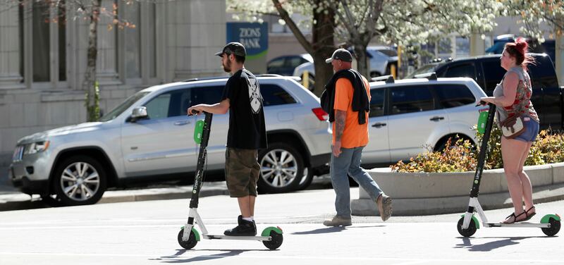 E-scooter renters ride down Main Street in Salt Lake City on Friday, April 19, 2019.