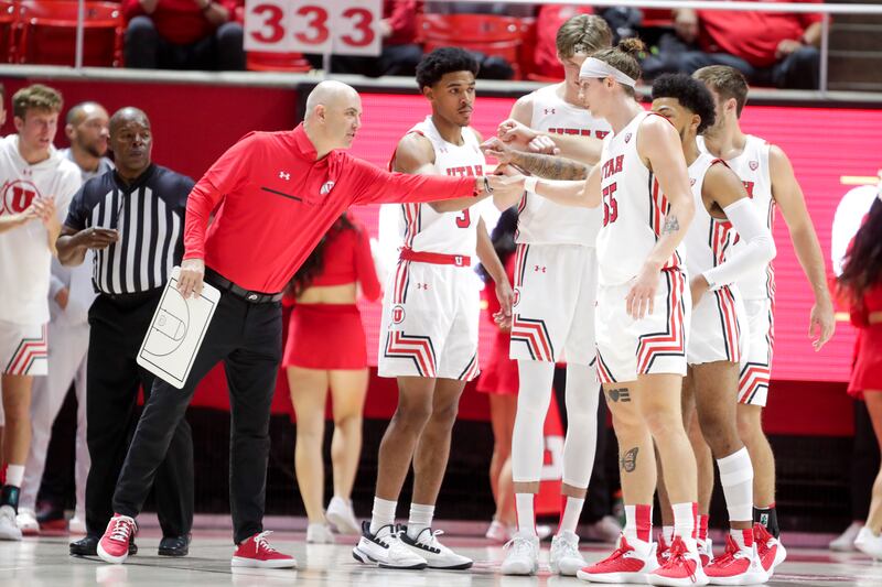Utah Runnin’ Utes head coach Craig Smith huddles with his players