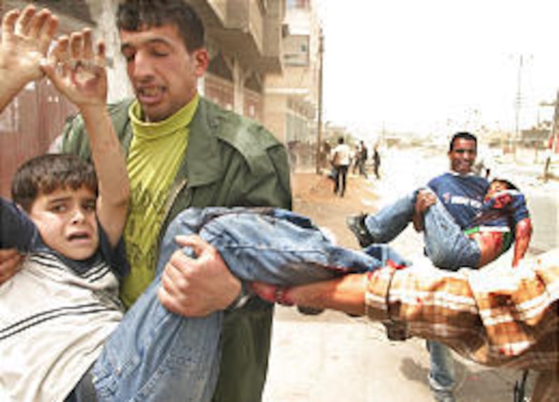 Palestinian men carry two wounded children moments after an Israeli missile strike on a demonstration in Rafah, southern Gaza Strip.