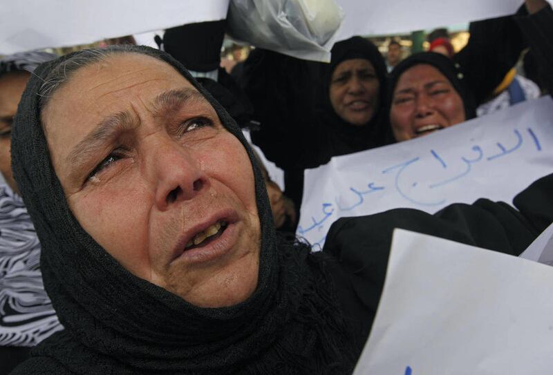 FILE - In this Feb. 20, 2011 file photo, women attend a protest to ask for the release of their relatives from jail in Cairo, Egypt. A few days after the revolt began on Jan. 25, police vanished from the streets and the military took over _ a transition t
