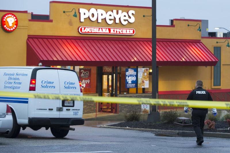 A police officer walks outside a Popeyes restaurant during an investigation into the shooting of a Prince George’s County police officer outside a police station, on Sunday, March 13, 2016, in Hyattsville, Md.
