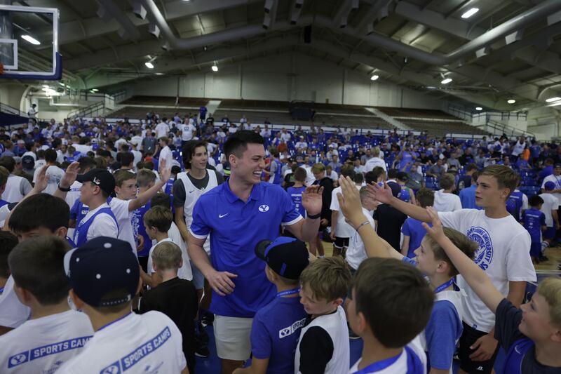 BYU’s Alex Barcello high-fives a participant during a Fathers and Sons basketball camp. Barcello announced he will return to play for BYU next season.