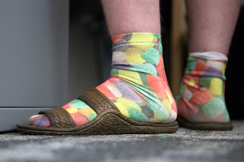 Tyler Newland wears colorful socks and sandals while working at CHG Healthcare Services' headquarters in Midvale on Wednesday, Aug. 8, 2018. Workers are wearing more casual attire as dress codes loosen, according to the Employers Council’s Miscellaneous B
