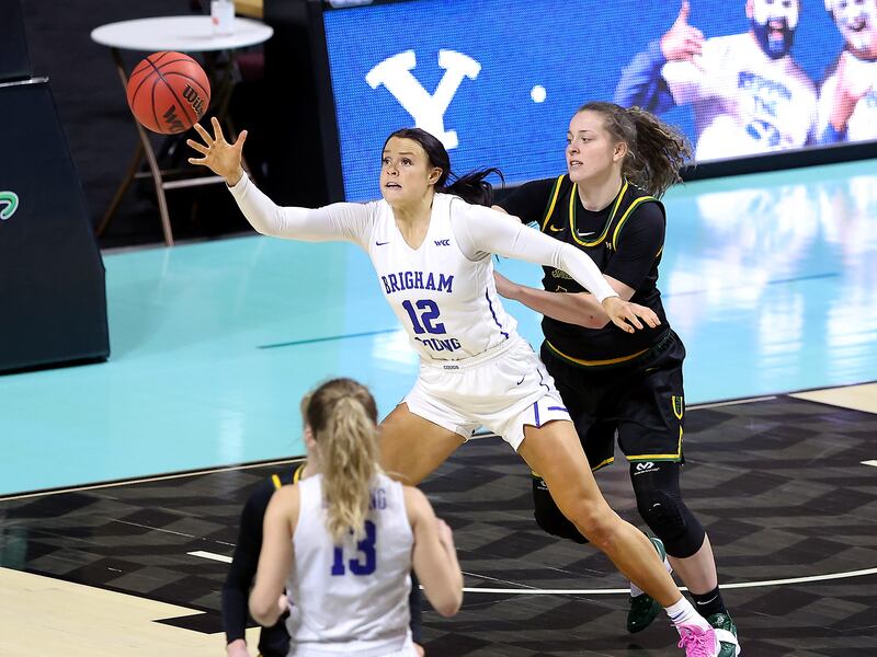 BYU Cougars forward Lauren Gustin (12) gets the pass as San Francisco Dons guard Lucie Hoskova (13) defends in West Coast Conference basketball tournament semifinal action.