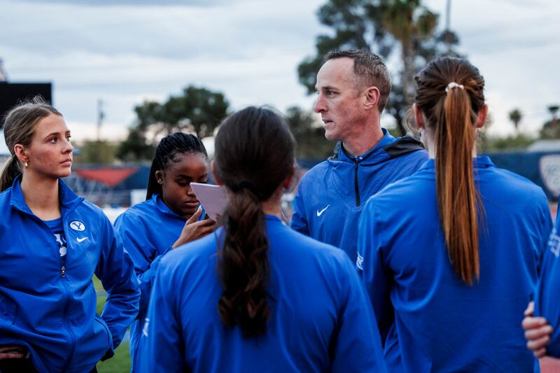 BYU sprint coach Kyle Grossarth huddles up with his runners during the Arizona Spring Break Fiesta on March 15, 2024.