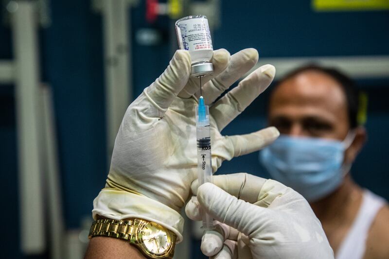 A health worker prepares to administer the COVAXIN vaccine for COVID-19 to a man at an indoor stadium in Gauhati, India, Thursday, April 22, 2021.