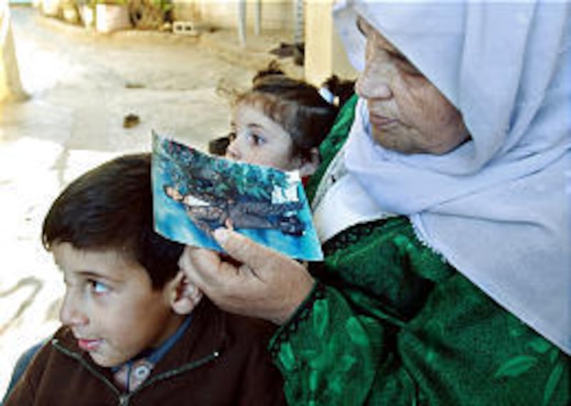Amnah Kamil, mother of Mahmoud Kamil Dobie, holds a picture of her son who was slain by Israeli troops.