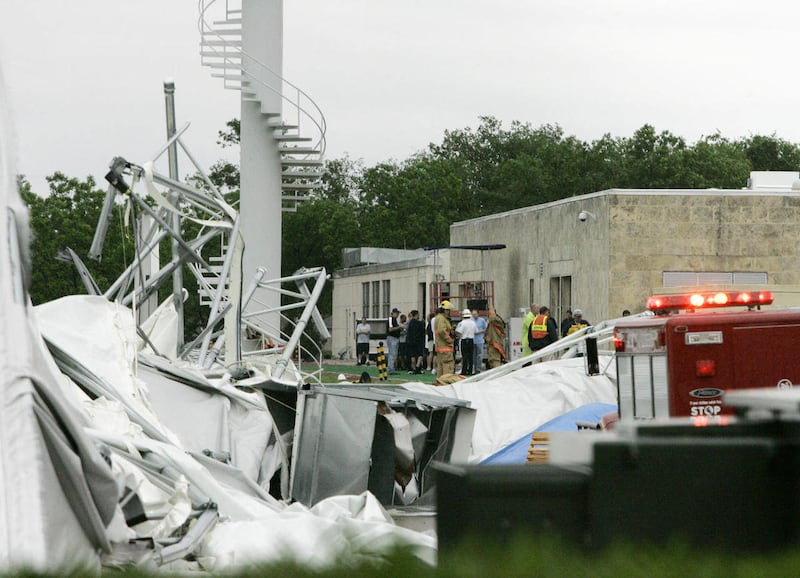 FILE - In this May 2, 2009 file photo, emergency personnel stand near the Dallas Cowboys practice field structure that collapsed during a passing storm in Irving, Texas. Tight end Jamar Hunt, a former Dallas Cowboys player who was inside the team's prac