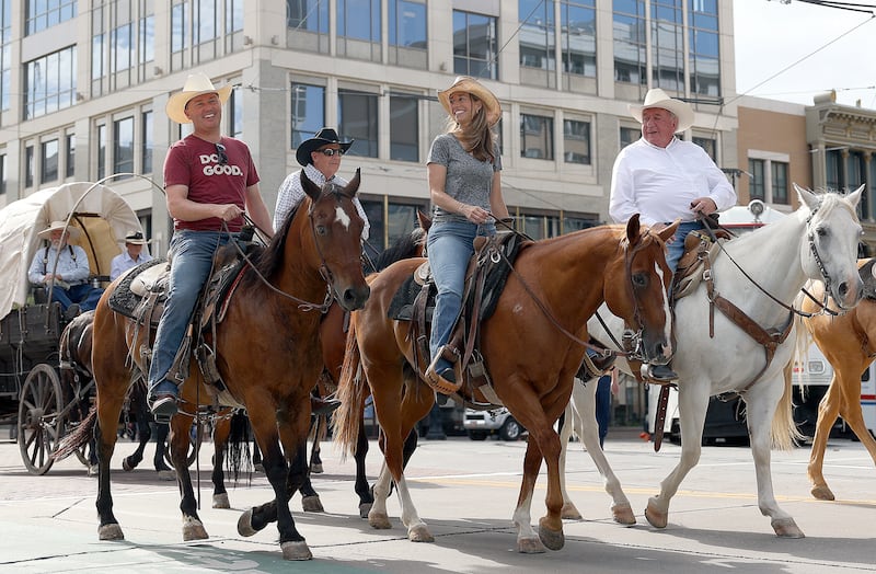 Gov. Spencer Cox, left, and first lady Abby Cox ride with the Days of ’47 cattle drive through downtown Salt Lake City.