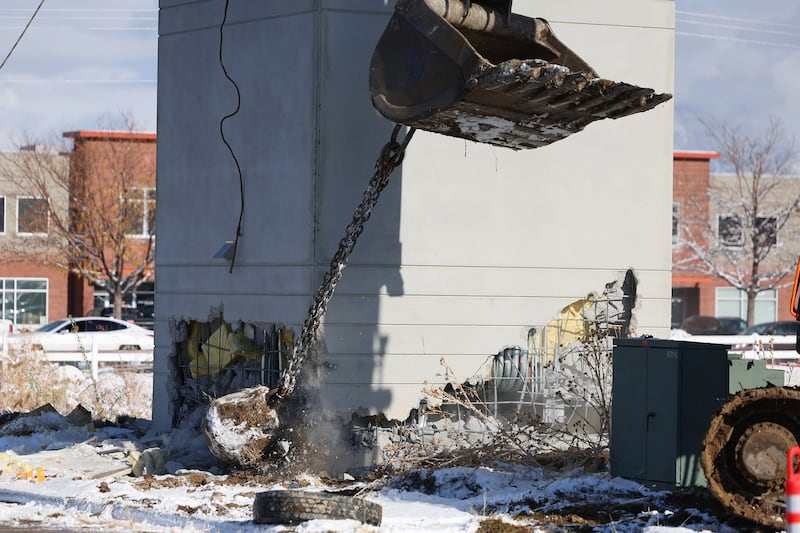 A worker uses a wrecking ball on a corner of a guard tower as they work to topple it over at the old state prison in Draper on Tuesday.