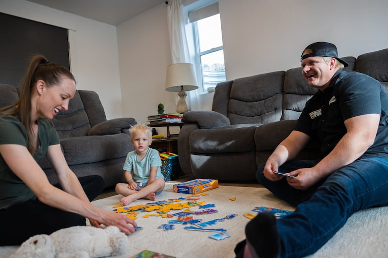 Blaine Davis and his wife Whitney play with their son McKoy, 2, at their home in Lehi on June 2, 2023.