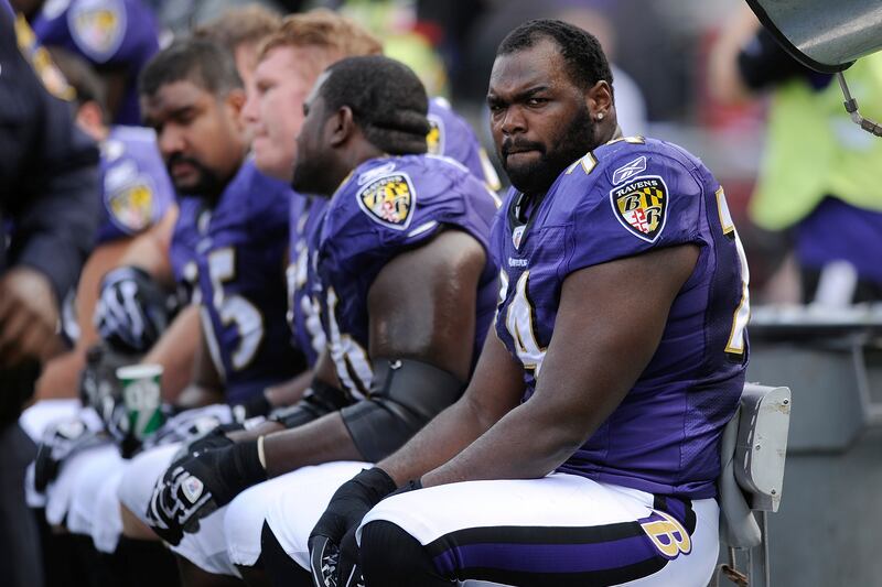 Michael Oher sits on the beach during the first half of an NFL football game in Baltimore.