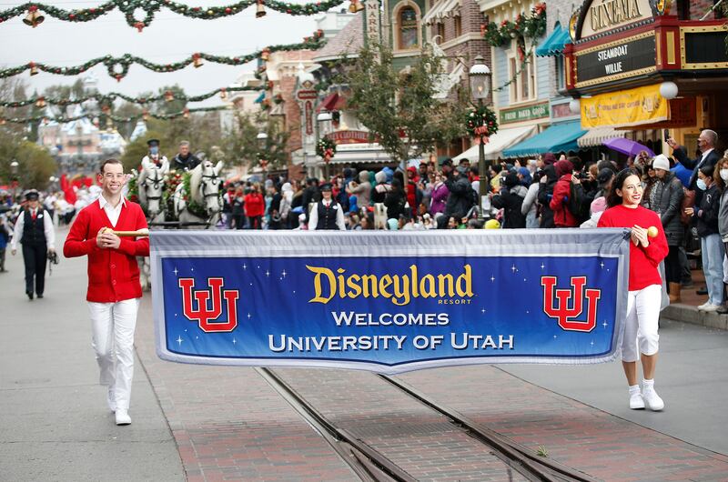 A parade for the Utah Utes and Ohio State Buckeyes makes its way through Disneyland.
