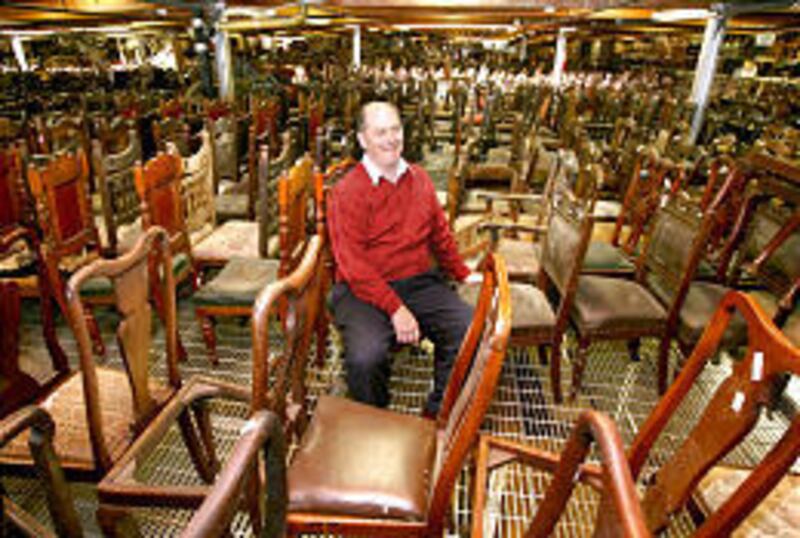 Salt Lake antique dealer Scott Evans sits amid 1,200 of his chairs.