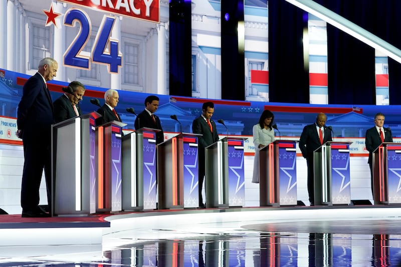 GOP candidates listen to a prayer before a Republican presidential primary debate on Wednesday, Aug. 23, 2023, in Milwaukee.
