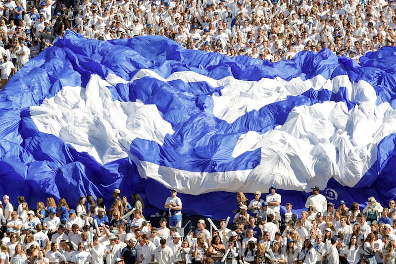 Fans in the student section hold up a BYU banner during a football game at LaVell Edwards Stadium in Provo, Oct. 15, 2022.