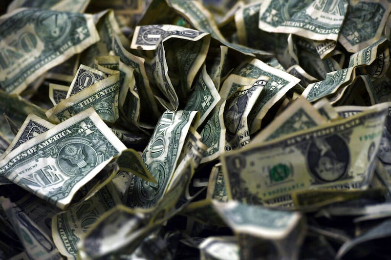 Dollar bills sit on a table.