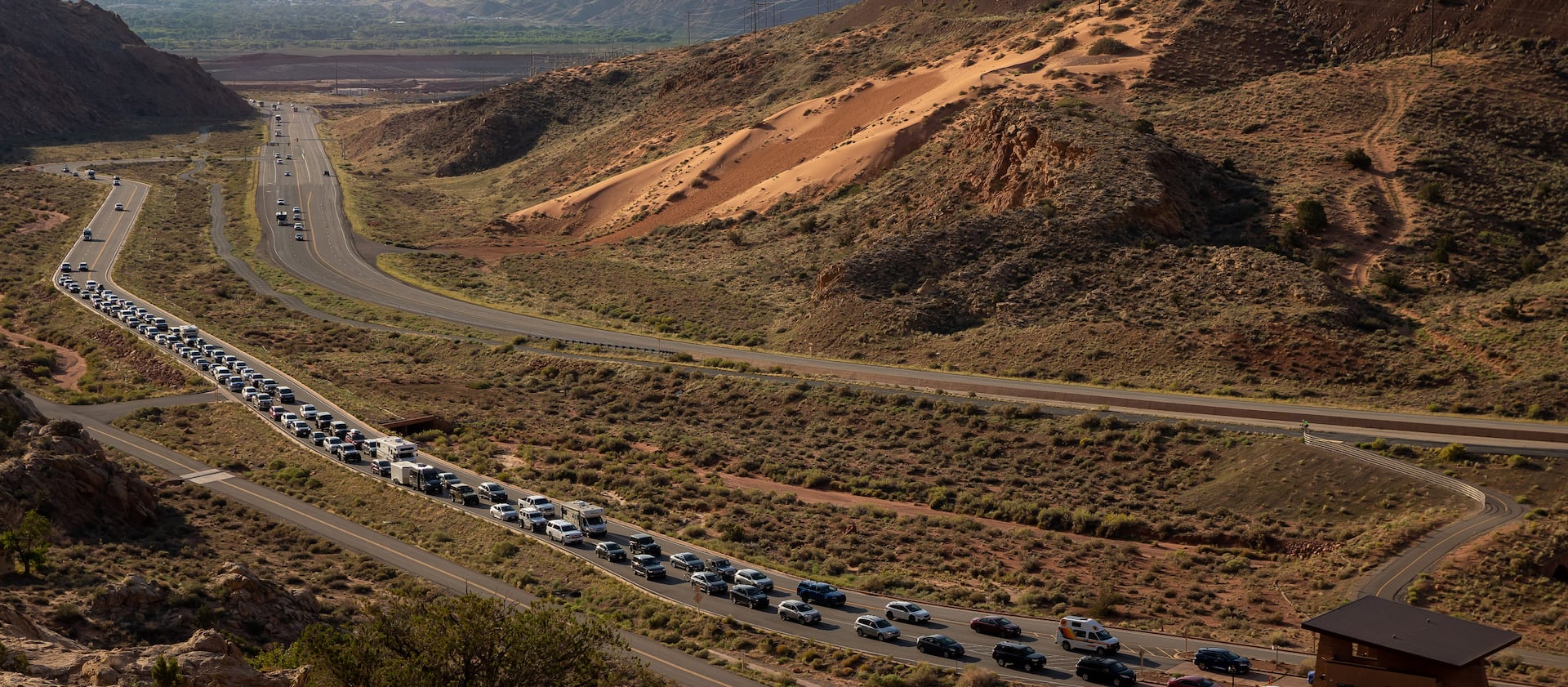 The entrance road to Arches National Park outside Moab begins to back up with visitors on Sunday, Sept. 19, 2021.