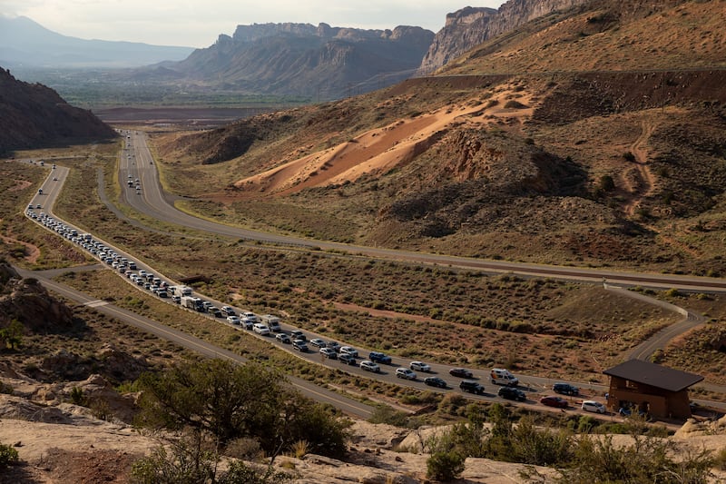 The entrance road to Arches National Park outside Moab begins to back up with visitors on Sunday, Sept. 19, 2021.