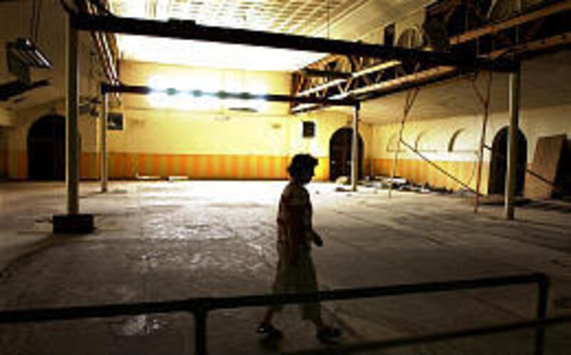 Debbie Warren walks through the rundown dining hall, one of only three historic buildings left of as many as 100 that once made up the Phoenix Indian School.