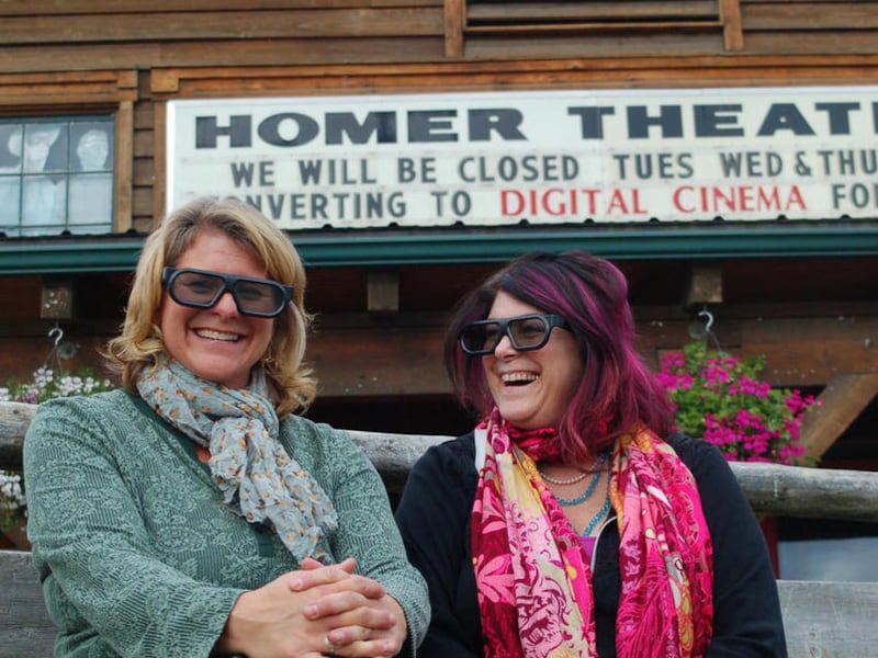 Homer Theatre programming manager Colleen Carroll, left, and Robin Daugherty, right, operations manager, model the glasses used to view 3-D films while sitting in front of the 53-year-old movie theater in Homer, Alaska on Sept. 22, 2011. After 55 years, t