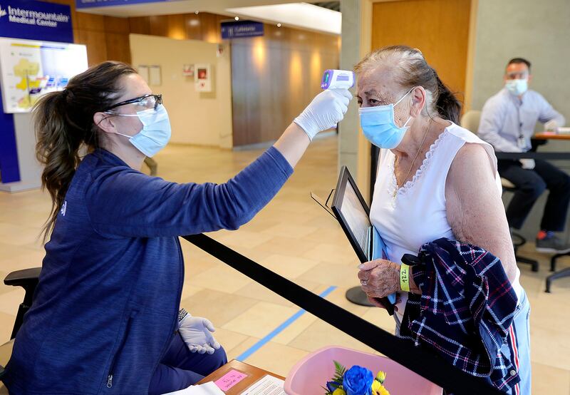 Rikki Gerrard, a registered nurse, checks Mary Gallegos’ temperature as she arrives to visit her son at Intermountain Medical Center in Murray on Tuesday, June 23, 2020. Intermountain requires all visitors and patients to wear a mask, sanitize their hands and get a temperature check upon arrival.