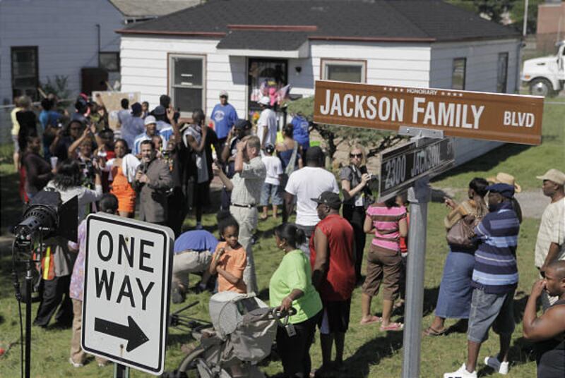 Mourners and media gather outside the boyhood home of pop star Michael Jackson on Friday in Gary, Ind.